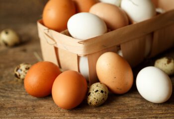 Fresh chicken and quail eggs on a wooden rustic background